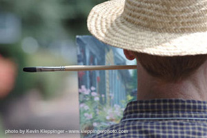 Photo of Robert painting with brush in mouth