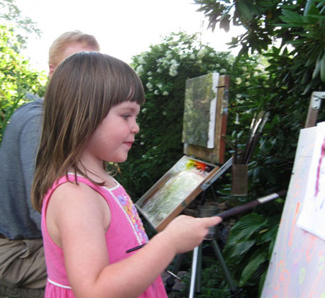 Photo of Sofia painting at her watercolor easel